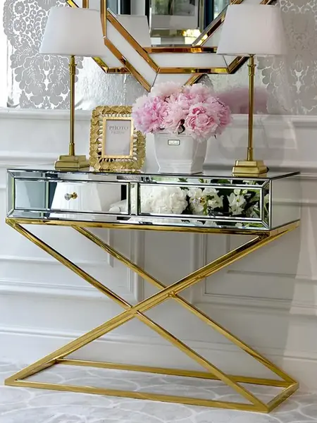 Konsola lustrzana CHICAGO GOLD glamour stalowa złota w świetle dziennym, eksponująca swój blask. Ekspozycja w salonie Primavera Home.