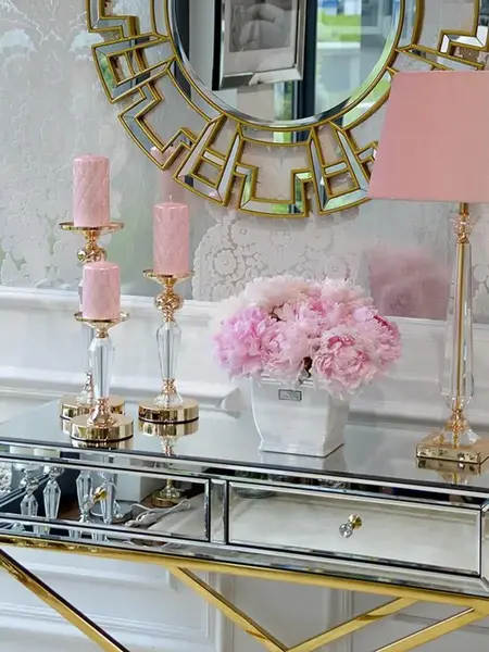 Widok z ukosa na konsolę lustrzaną CHICAGO GOLD glamour stalową złotą, ukazujący jej elegancką formę. Ekspozycja w salonie Primavera Home.