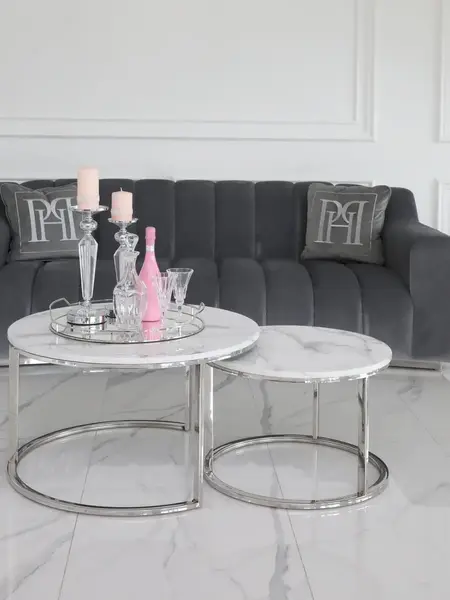 Ekspozycja w showroomie z okrągłym stolikiem kawowym srebrnym z marmurowym blatem 2w1, prezentującym elegancki styl. Meble na zamówienie od Primavera Home.