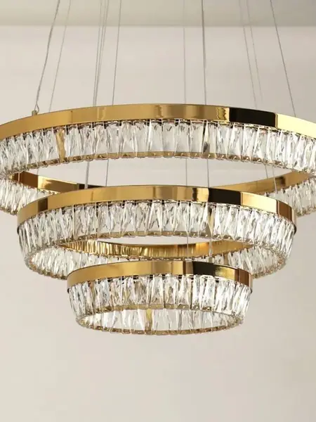 Żyrandol kryształowy złoty BELLINI XL w aranżacji nowoczesnego salonu. Ekskluzywna lampa od Primavera Home.