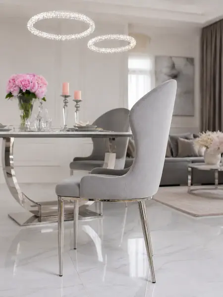 Zbliżenie na stalowe nogi ekskluzywnego krzesła do jadalni glamour. Aranżacja nowoczesnego wnętrza od Primavera Home.