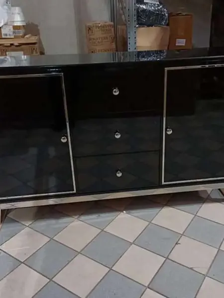 Widok z daleka na komodę lakierowaną czarną Lorenzo L Silver w eleganckim otoczeniu. Aranżacja nowoczesnego wnętrza od Primavera Home.