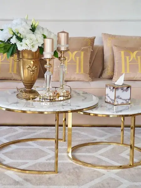 Stolik kawowy okrągły glamour, złoty, biały marmur MARCO GOLD na tle nowoczesnych salonów. Ekspozycja w salonie od Primavera Home.