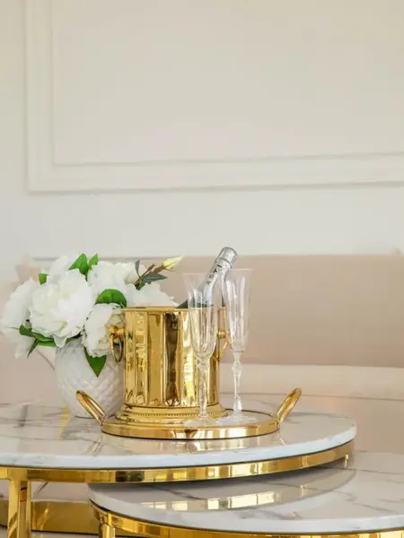 Stolik kawowy okrągły glamour, złoty, biały marmur MARCO GOLD na tle innych mebli w salonie. Ekspozycja w salonie od Primavera Home.