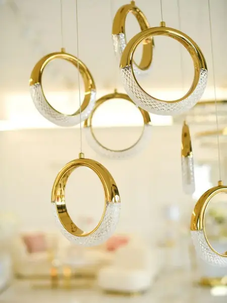 Żyrandol w blasku światła, eksponujący jego elegancki kształt. Z kolekcji Primavera Home.
