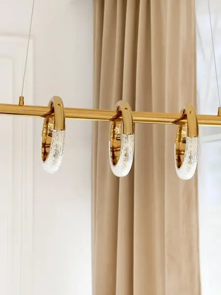 Lampa wisząca w jasnym wnętrzu, podkreślająca przestronność. Ekspozycja w salonie od Primavera Home.