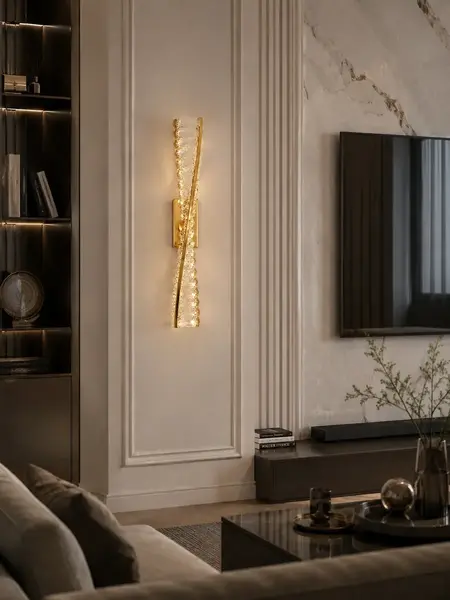 Kinkiet Kryształowy Złoty Podłużny Crystal w nocnym świetle, tworzący nastrojową atmosferę. Detal wykończenia od Primavera Home.