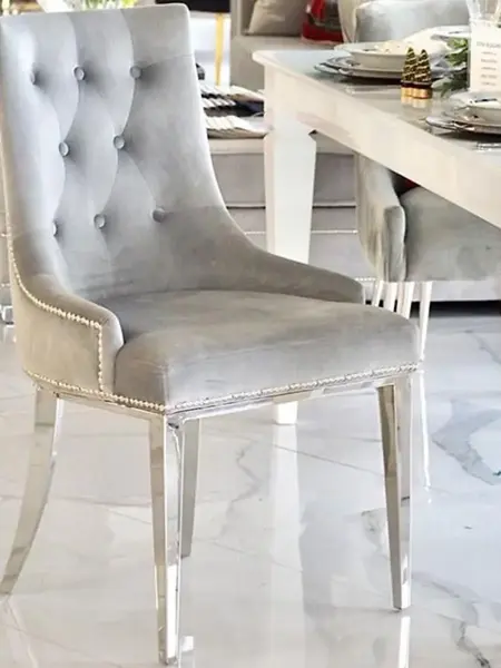 Luksusowe krzesło glamour, pikowane z kołatką, do jadalni, na stalowych, prostych nogach, szare, srebrne MADAME w stylizowanej aranżacji. Ekspozycja w salonie od Primavera Home.