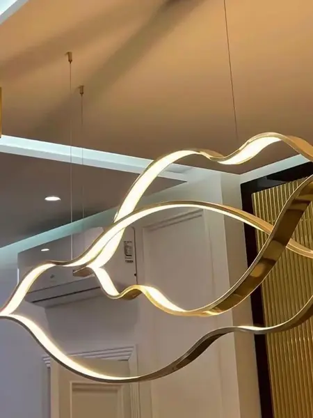 Złoty Żyrandol Nowoczesny Wave – Designerska Lampa Fala LED w artystycznym ujęciu, eksponująca nowoczesny design. Oświetlenie na zamówienie od Primavera Home.