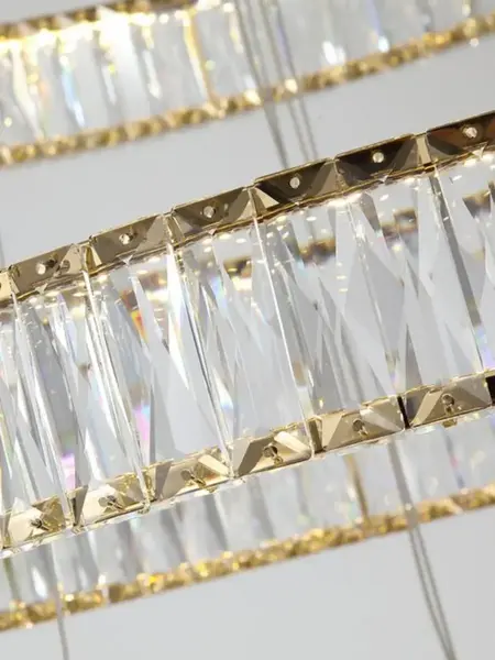 Stylizacja z Żyrandolem Kryształowym Złotym Crystal XL Trzypoziomowym na tle designerskiej szafki. Nowoczesność od Primavera Home.