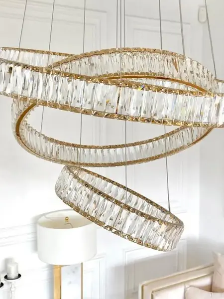 Żyrandol Kryształowy Złoty Crystal XL Trzypoziomowy na tle czarnych ścian. Przeciwwaga dla elegancji od Primavera Home.