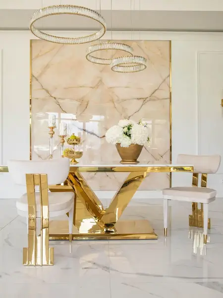 Ekskluzywny stół glamour do jadalni, nowoczesny, z białym konglomeratem, złoty LV COLLECTION w ujęciu z przodu. Oświetlenie na zamówienie od Primavera Home.