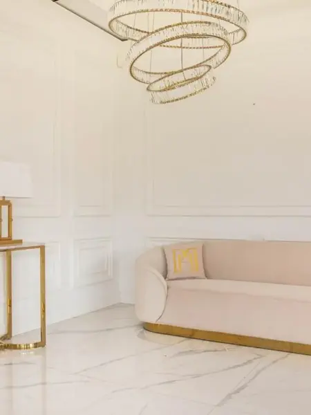 Fragment pomieszczenia z sofą Beżowa Glamour Aksamitna FLORENCE Złote Nogi, która wprowadza elegancję do wnętrza. Meble na zamówienie od Primavera Home.