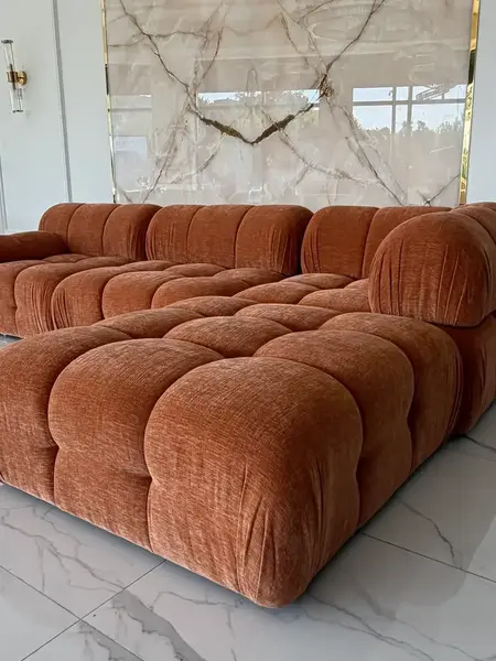 Detal wykończenia nóg designerskiego narożnika modułowego boucle NICEA w eleganckim stylu. Meble na zamówienie od Primavera Home.