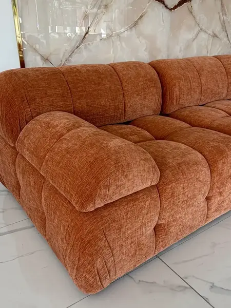 Widok otwarty na designerski narożnik modułowy boucle NICEA w przestronnej aranżacji. Primavera Home.