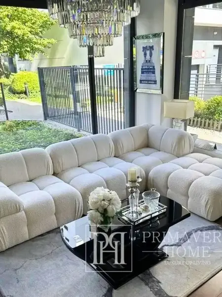 Perspektywa 3D pokazująca designerski narożnik modułowy boucle NICEA w przestronnej aranżacji. Primavera Home.