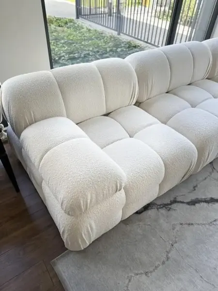 Zbliżenie na ramy designerskiego narożnika modułowego boucle NICEA w eleganckim wystroju. Primavera Home.