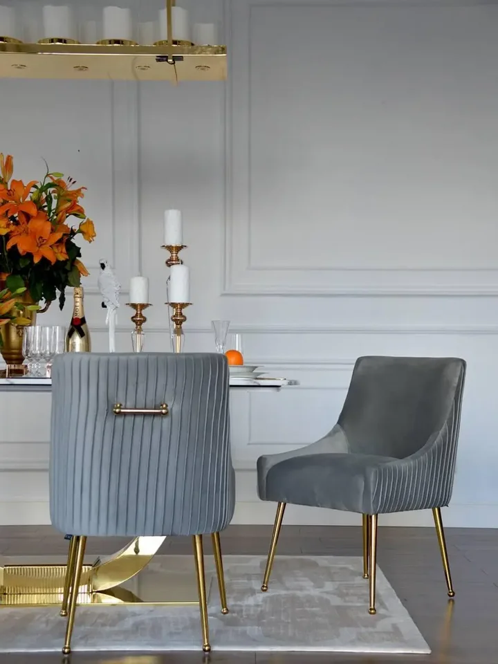 Cztery designerskie krzesła tapicerowane z kołatkami w pełnym zestawie, dostępne w ofercie Primavera Home.