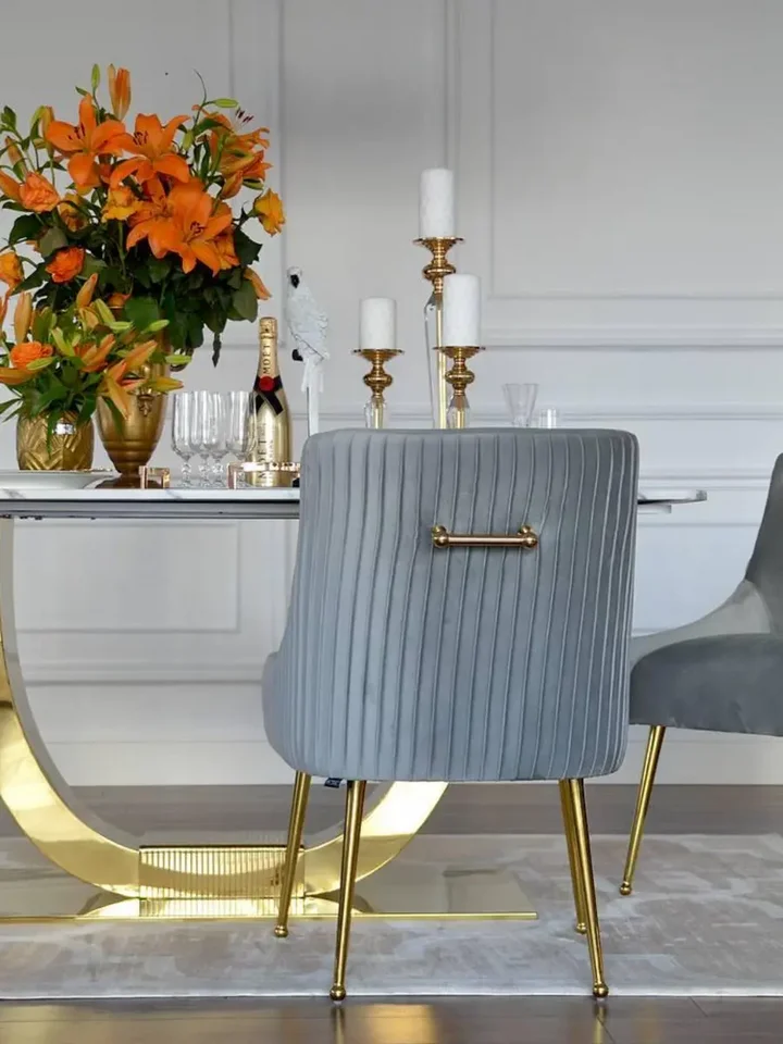 Znajdujące się w jasnym wnętrzu designerskie krzesło tapicerowane, z kołatką, od Primavera Home, idealne do jadalni.