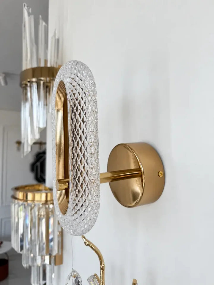 Kinkiet złoty, glamour, nowoczesny, lampa ścienna VALO na ciemnym tle, podkreślający jego subtelną urodę. Oświetlenie na zamówienie od Primavera Home.