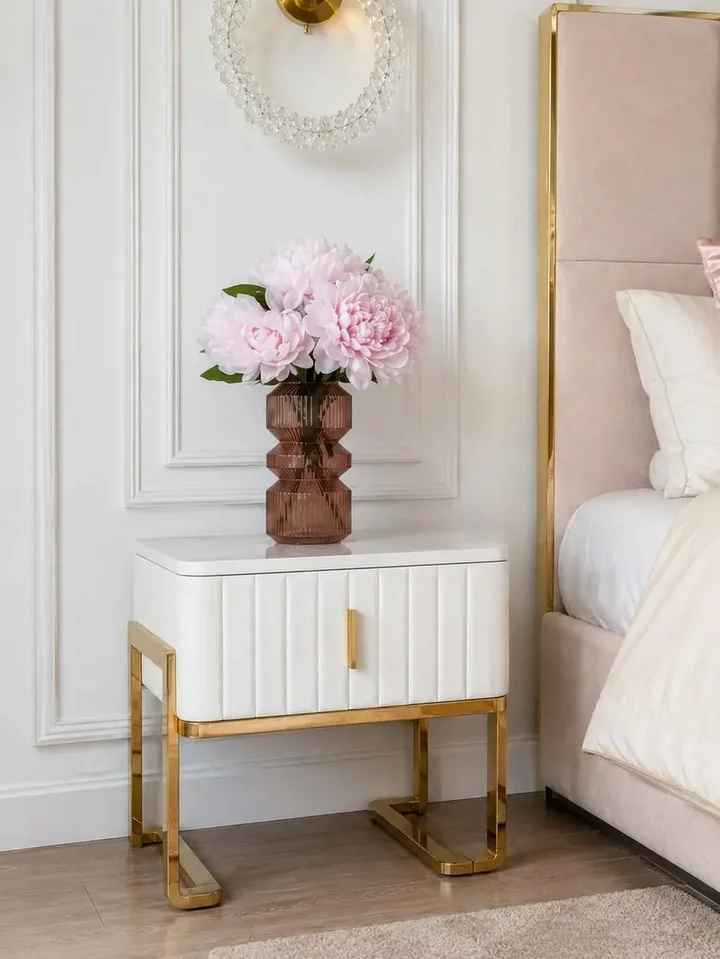 Szafka nocna glamour nowoczesna, beżowa, złota, stolik boczny z szufladą AMORE w ujęciu z przodu. Oświetlenie na zamówienie od Primavera Home.