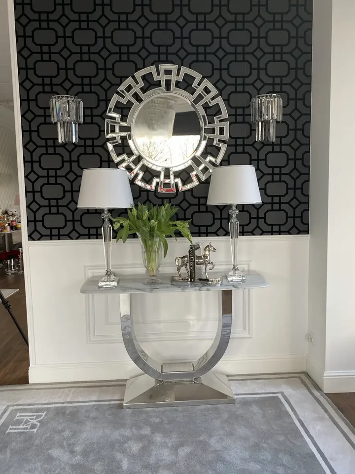 Konsola w stylu nowoczesnym glamour z białym marmurowym blatem srebrna ART DECO zaaranżowana w nowoczesnym salonie, podkreślając wysoki standard wykończenia. Oświetlenie od Primavera Home.