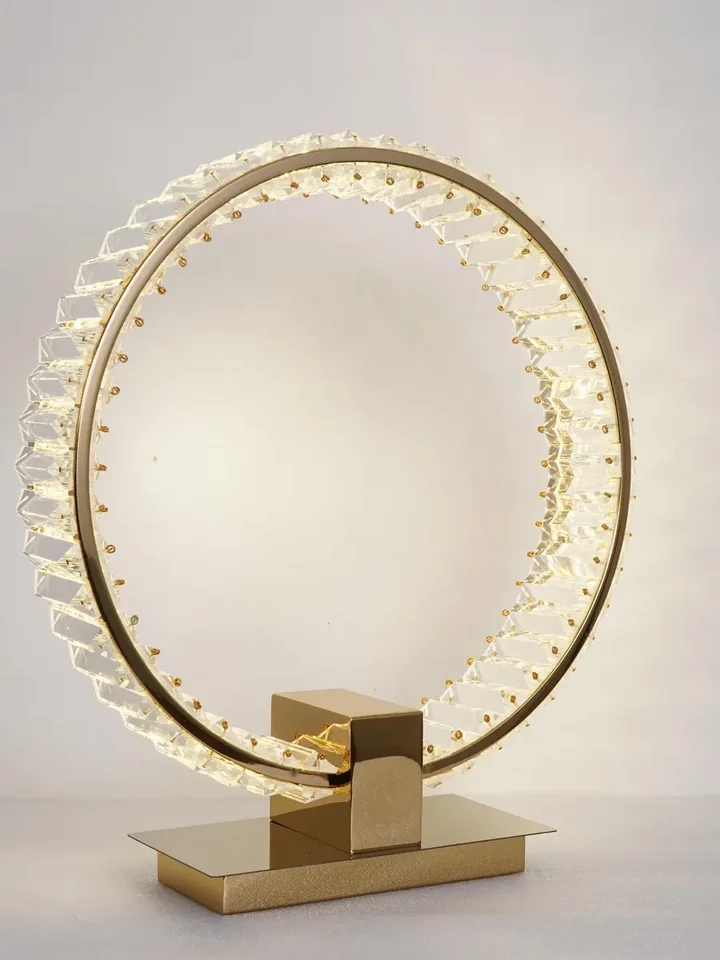 Lampa Stołowa Kryształowa Ring Złota Eclipse w nocnej atmosferze, tworzy przytulne wnętrze. Oświetlenie od Primavera Home.