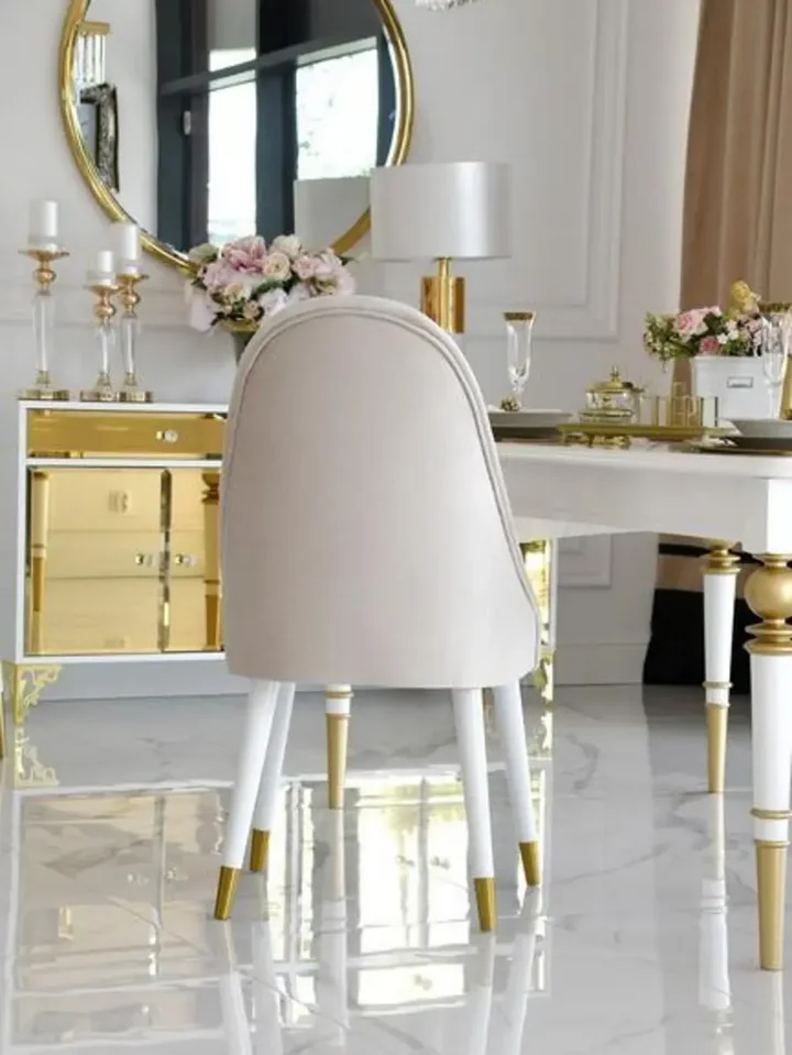 Perspektywa na krzesło złote tapicerowane glamour, ukazująca jego nowoczesny design w aranżacji od Primavera Home.