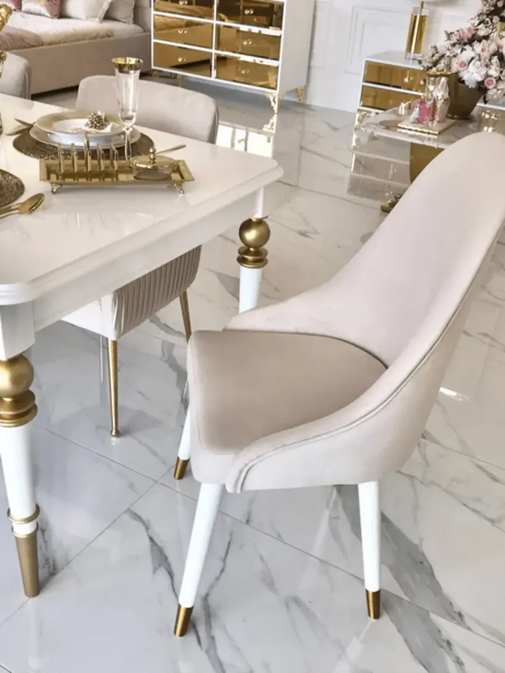 Krzesło złote tapicerowane glamour w jasnym wnętrzu, prezentujące elegancję i styl od Primavera Home.