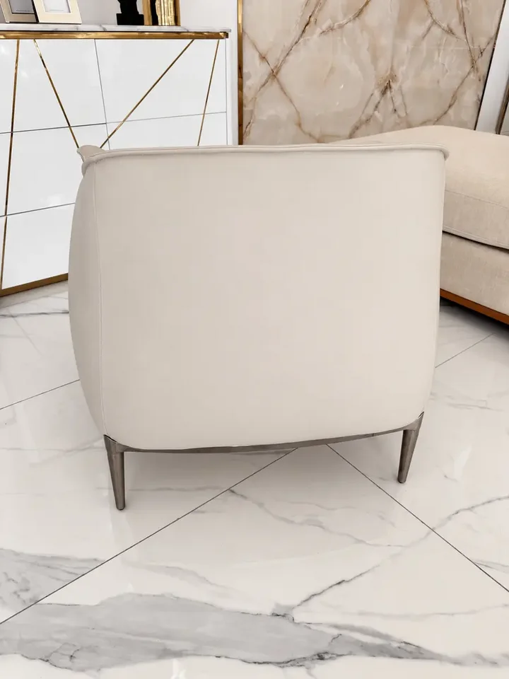 Perspektywa na Nowoczesny wygodny fotel luksusowy do salonu z podnóżkiem MODERN w przestronnej aranżacji. Detal wykończenia od Primavera Home.