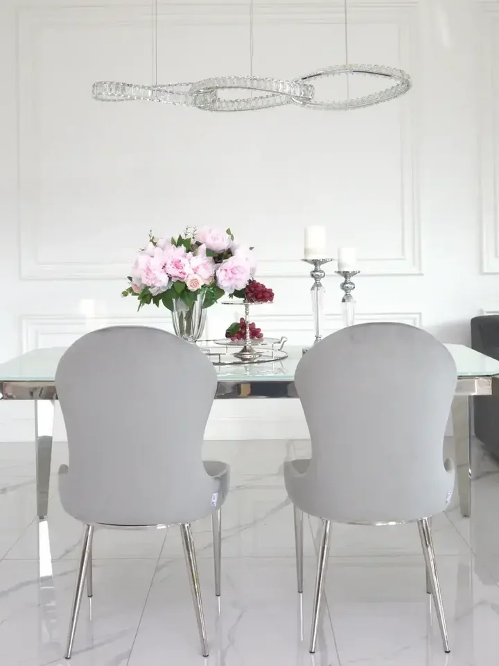 Bliskie ujęcie designerskiego stołu glamour ze szklanym blatem, stalowego, nowoczesnego, srebrnego ELITE, ukazujące jego wyjątkowe detale, dostępnego w Primavera Home.