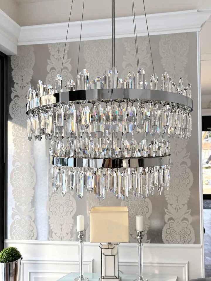 Żyrandol Kryształowy Bulgari XL Srebrny w jasnym wnętrzu, podkreślającym jego elegancję. Element wystroju od Primavera Home.