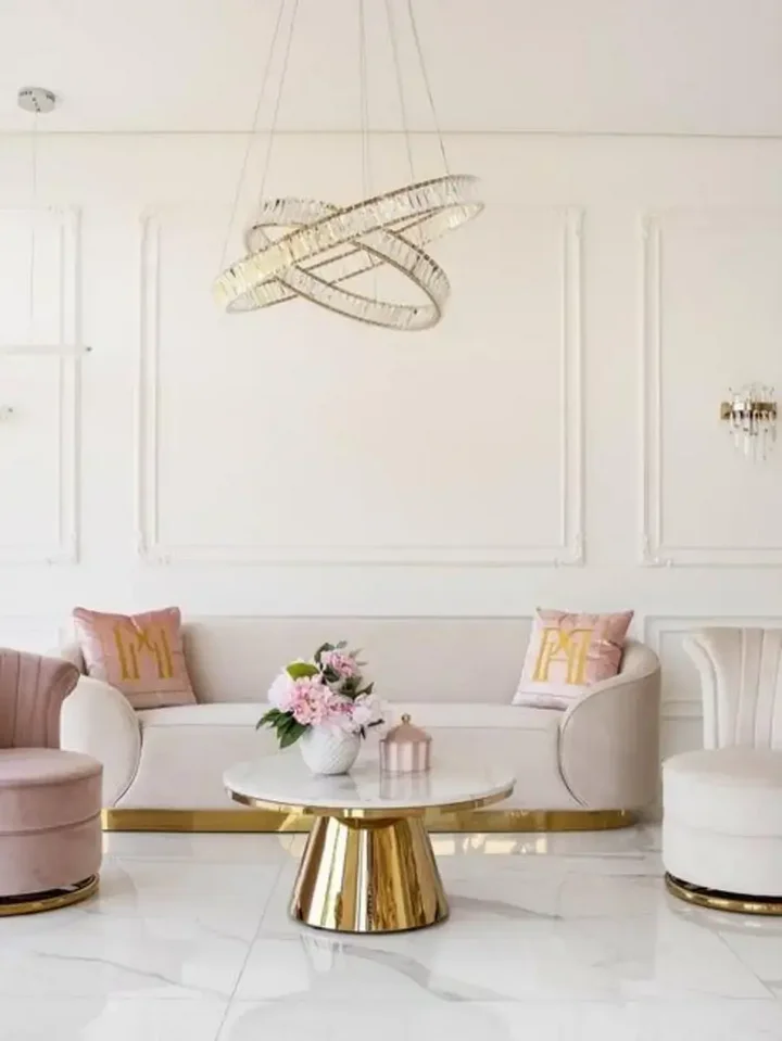 Sofa Beżowa Glamour Aksamitna FLORENCE Złote Nogi umiejscowiona przy oknie, w jasnym wnętrzu od Primavera Home.