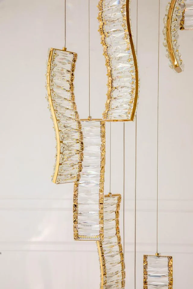 Zjawiskowy Żyrandol Kryształowy Złoty Crystal Long w ciemnym wnętrzu, tworzący niepowtarzalny klimat. Oferta Primavera Home.