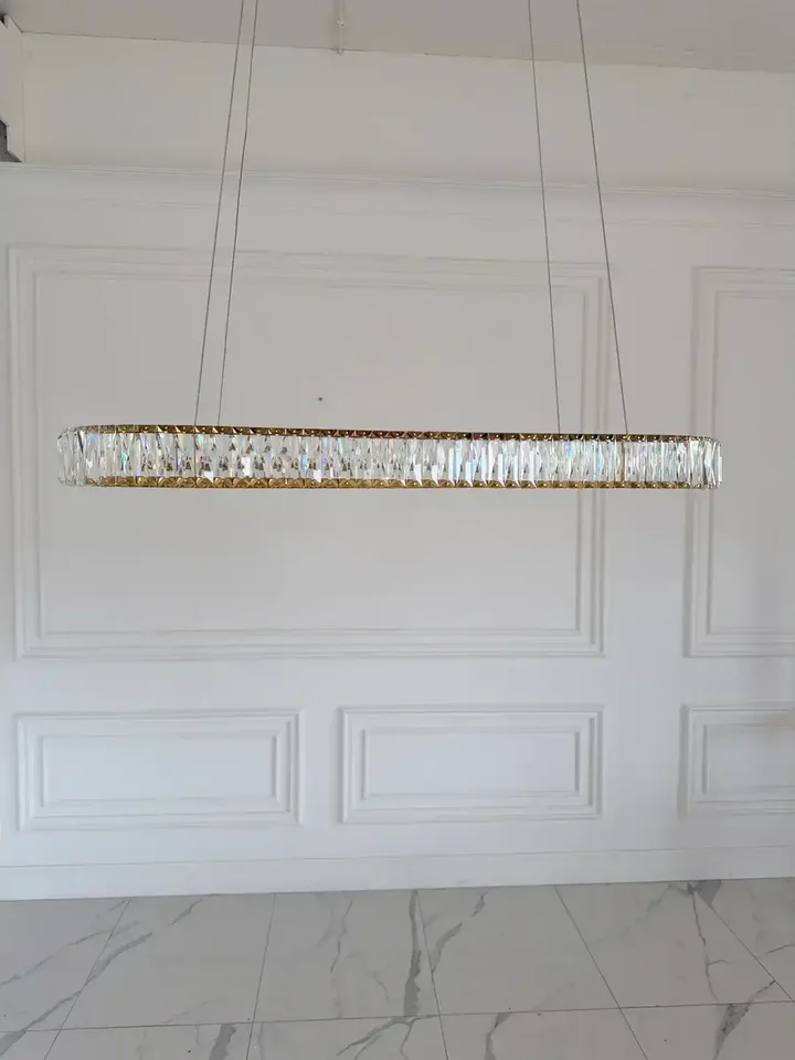 Żyrandol nowoczesny złoty Crystal w dużej przestrzeni, doskonale wypełniający wysokość pomieszczenia od Primavera Home.