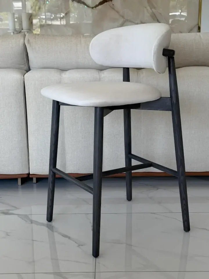 Hoker drewniany nowoczesny tapicerowany do wyspy krzesło barowe skandynawski OLIVIA w jasnym, minimalistycznym wnętrzu. Aranżacja nowoczesnego wnętrza od Primavera Home.