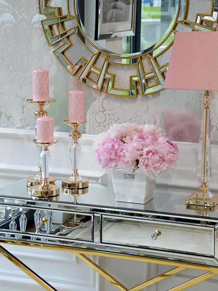 Widok z ukosa na konsolę lustrzaną CHICAGO GOLD glamour stalową złotą, ukazujący jej elegancką formę. Ekspozycja w salonie Primavera Home.