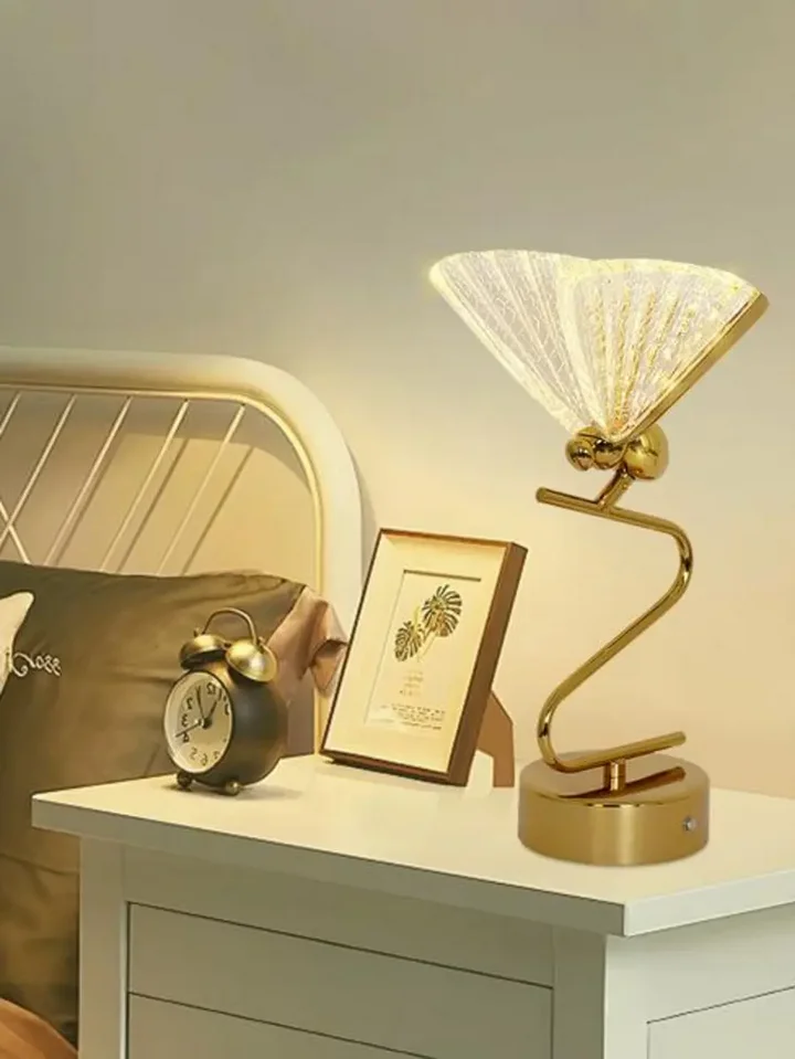 Widok Lampy Stołowej Motyl Złota umieszczonej na eleganckim stole. Ekspozycja w salonie od Primavera Home.
