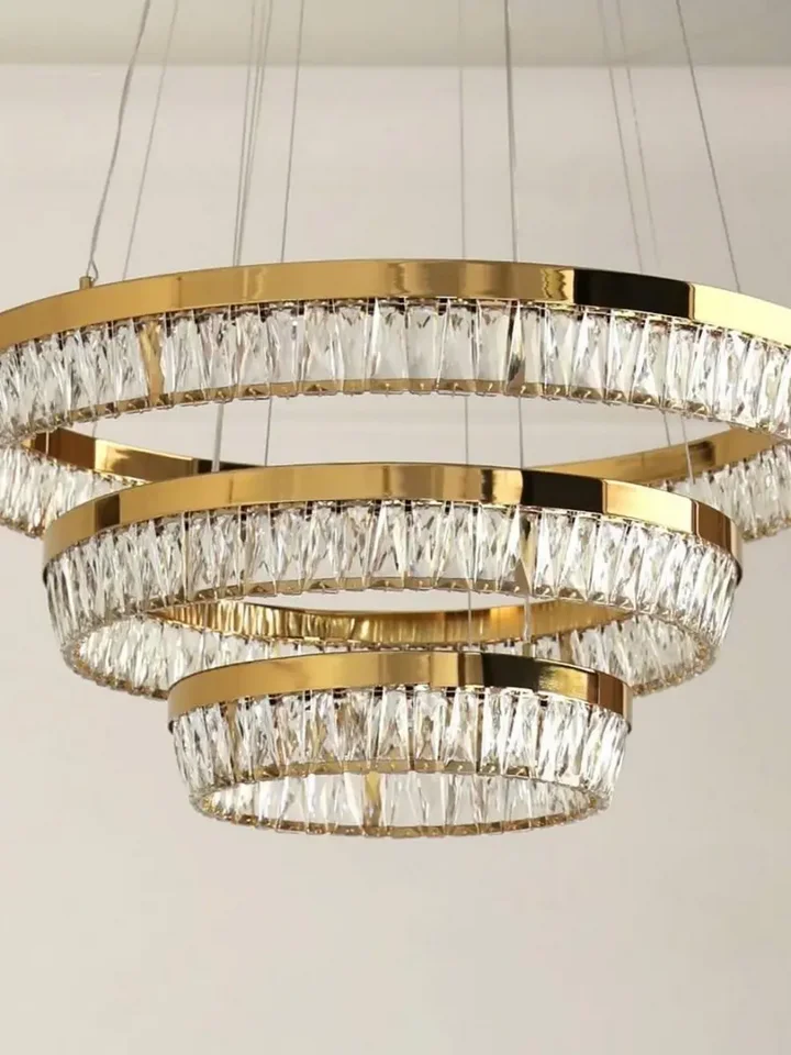 Żyrandol kryształowy złoty BELLINI XL w aranżacji nowoczesnego salonu. Ekskluzywna lampa od Primavera Home.