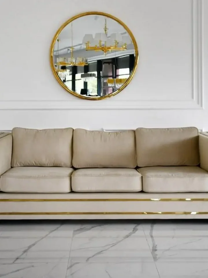 Sofa umieszczona w jasnym wnętrzu, podkreślająca styl glamour. Meble na zamówienie od Primavera Home.