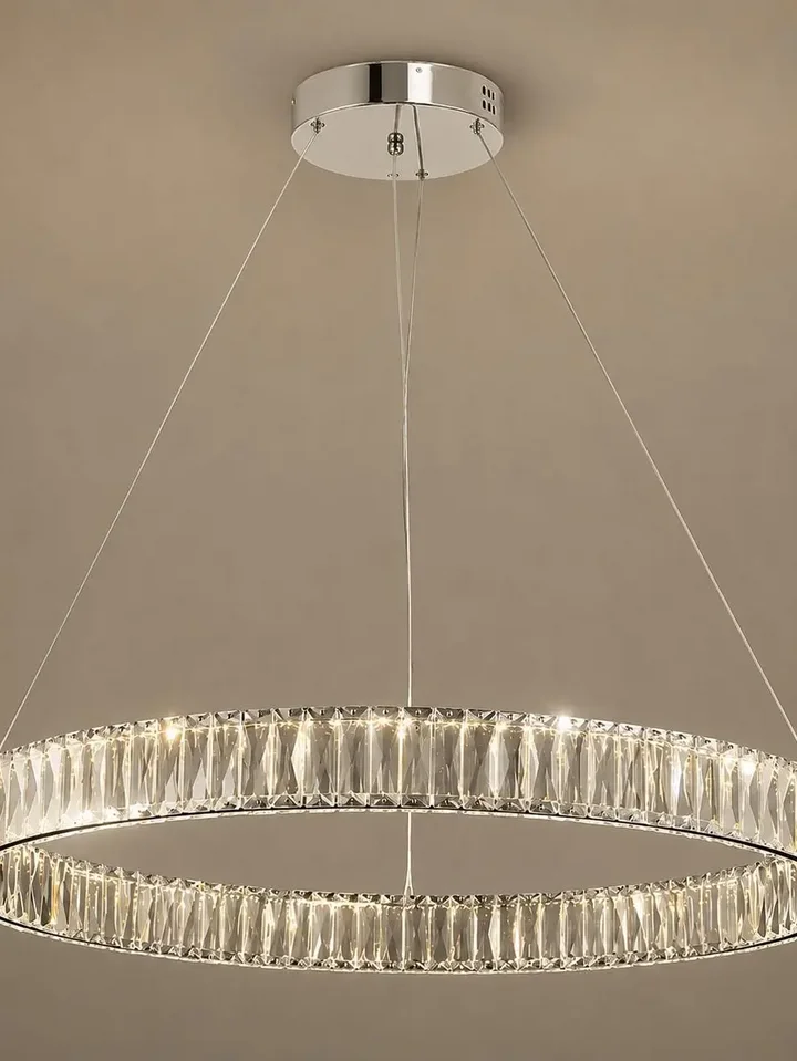 Z bliska pokazany Żyrandol Kryształowy Crystal Srebrny Glamour w przyciemnionej atmosferze. Aranżacja nowoczesnego wnętrza od Primavera Home.