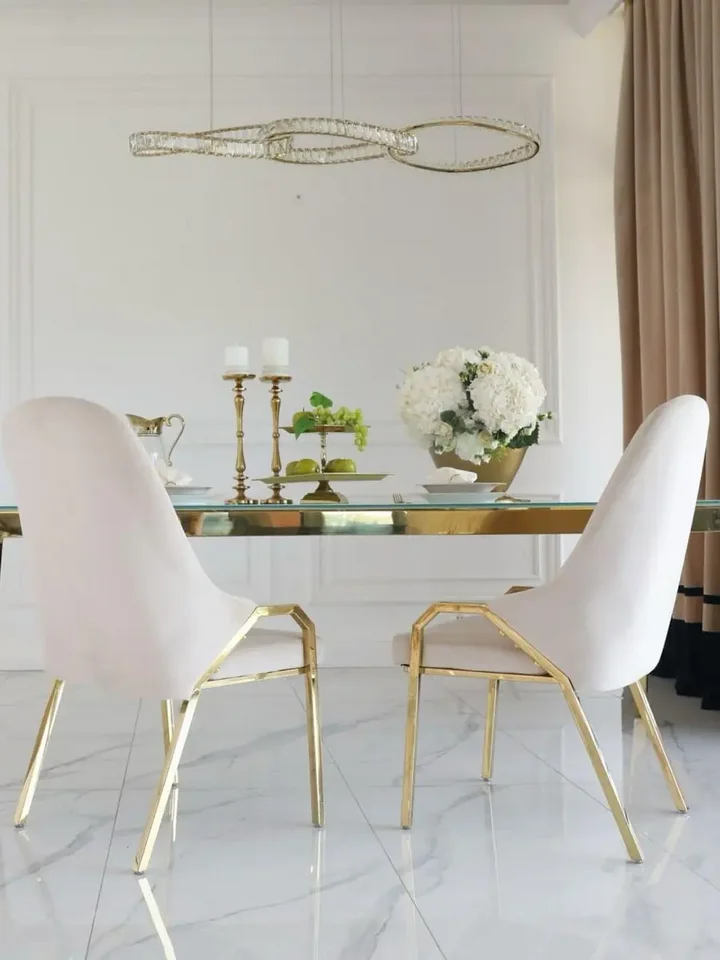 Zbliżenie na szklany blat designerskiego stołu do jadalni, glamour, stalowego, złotego ELITE. Ekspozycja w salonie od Primavera Home.