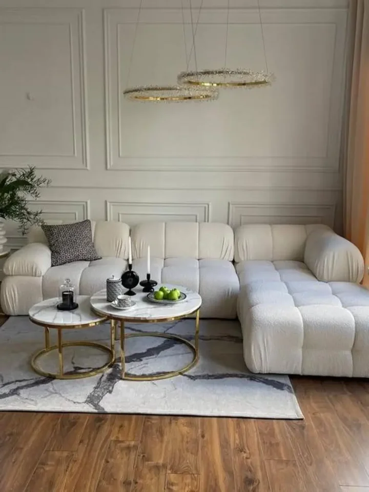 Widok na designerski narożnik modułowy boucle NICEA przy dużym oknie. Meble na zamówienie od Primavera Home.