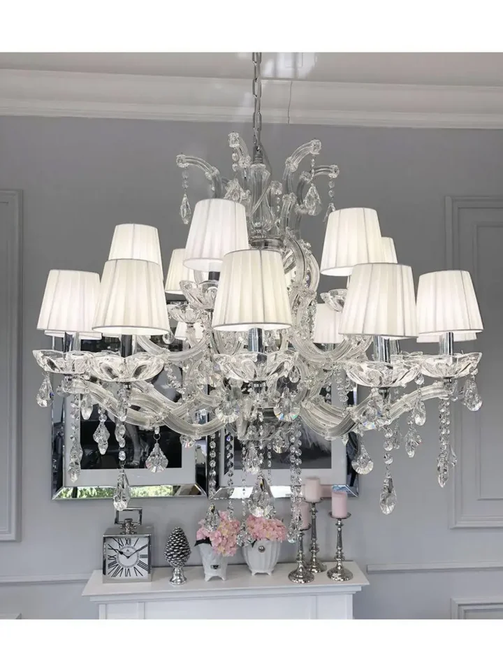 Widok na żyrandol w eleganckiej aranżacji z zasłonami, tworzącymi przytulną atmosferę. Oferowane przez Primavera Home.