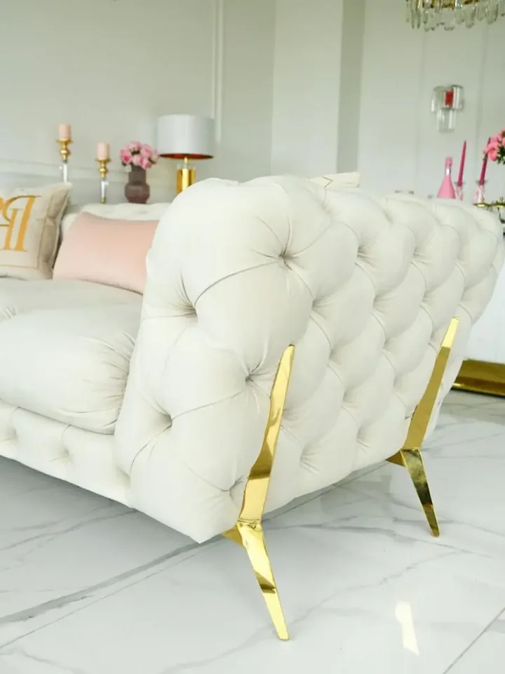 Luksusowa złota sofa pikowana DIVA GOLD w aranżacji z detalem ekspozycji. Aranżacja nowoczesnego wnętrza od Primavera Home.