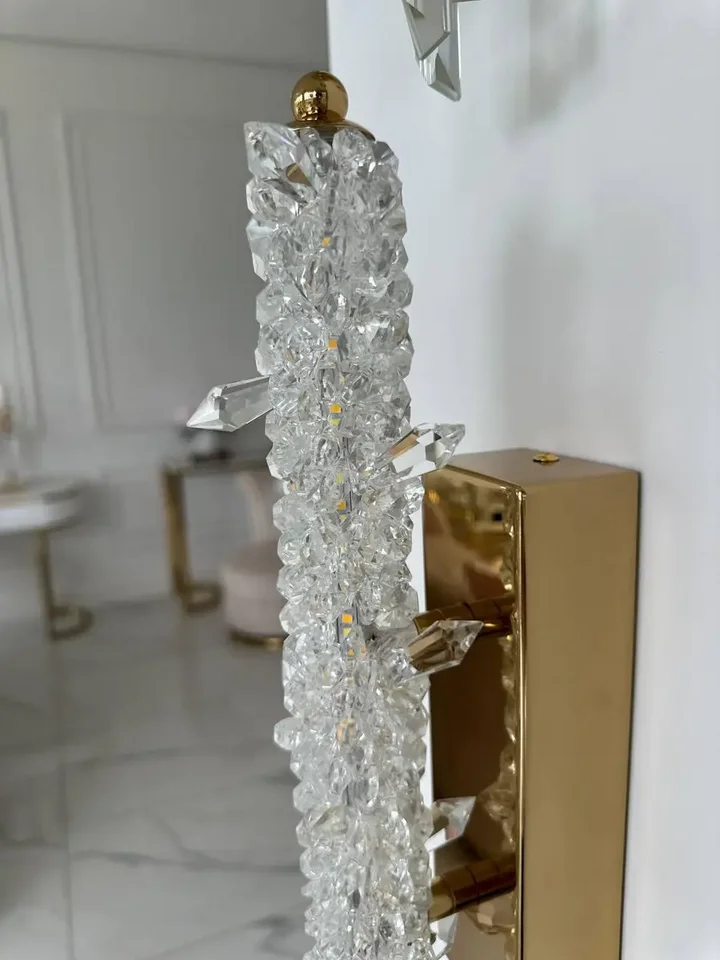 Złota lampa ścienna glamour w perspektywie bocznej. Doskonały detal wykończenia na tle mebli na zamówienie od Primavera Home.