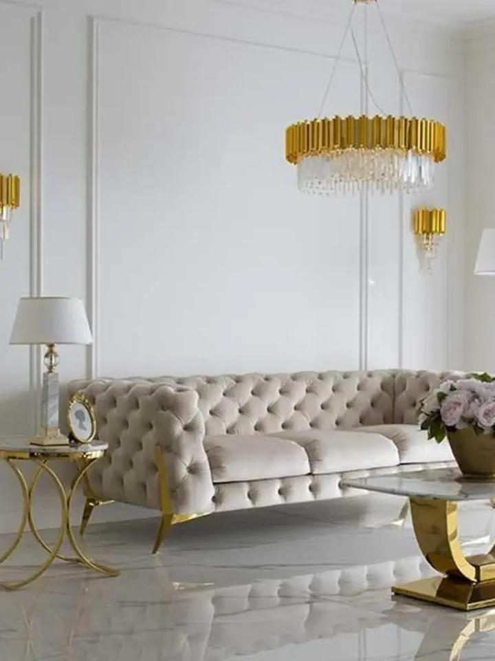 Luksusowa złota sofa pikowana DIVA GOLD w ujęciu z przodu. Oświetlenie na zamówienie od Primavera Home.
