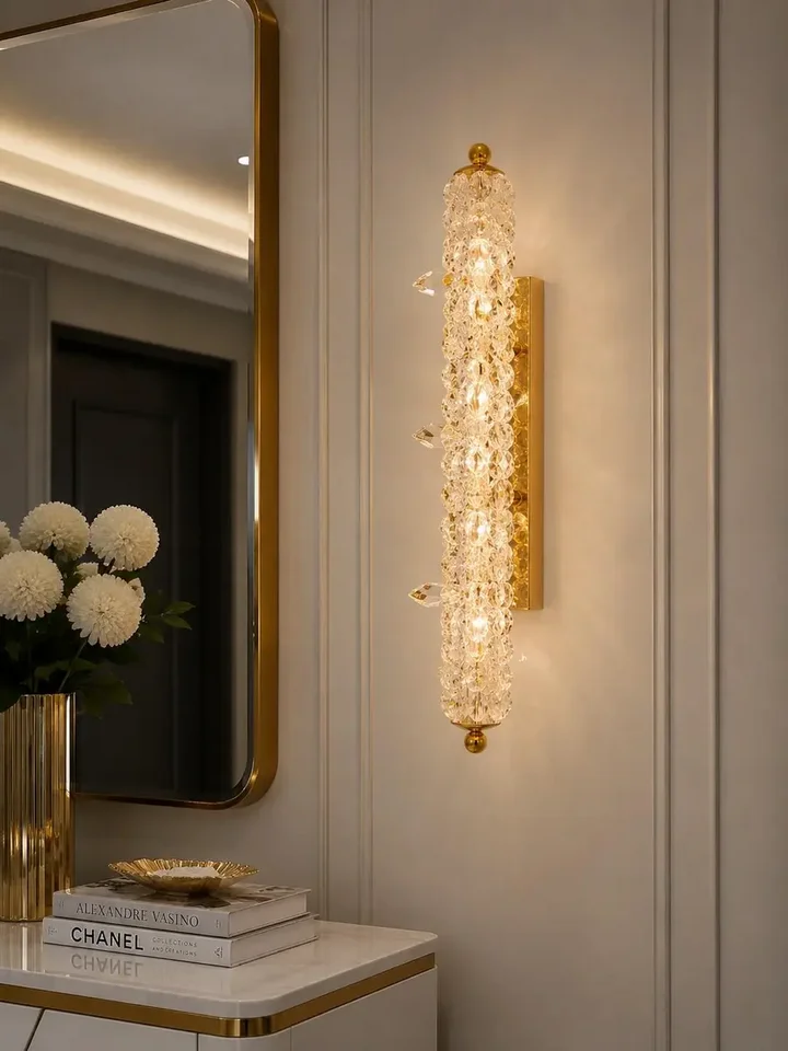 Zbliżenie na szkło kryształowe kinkietu, ukazujące jego błysk i urok w eleganckiej przestrzeni od Primavera Home.