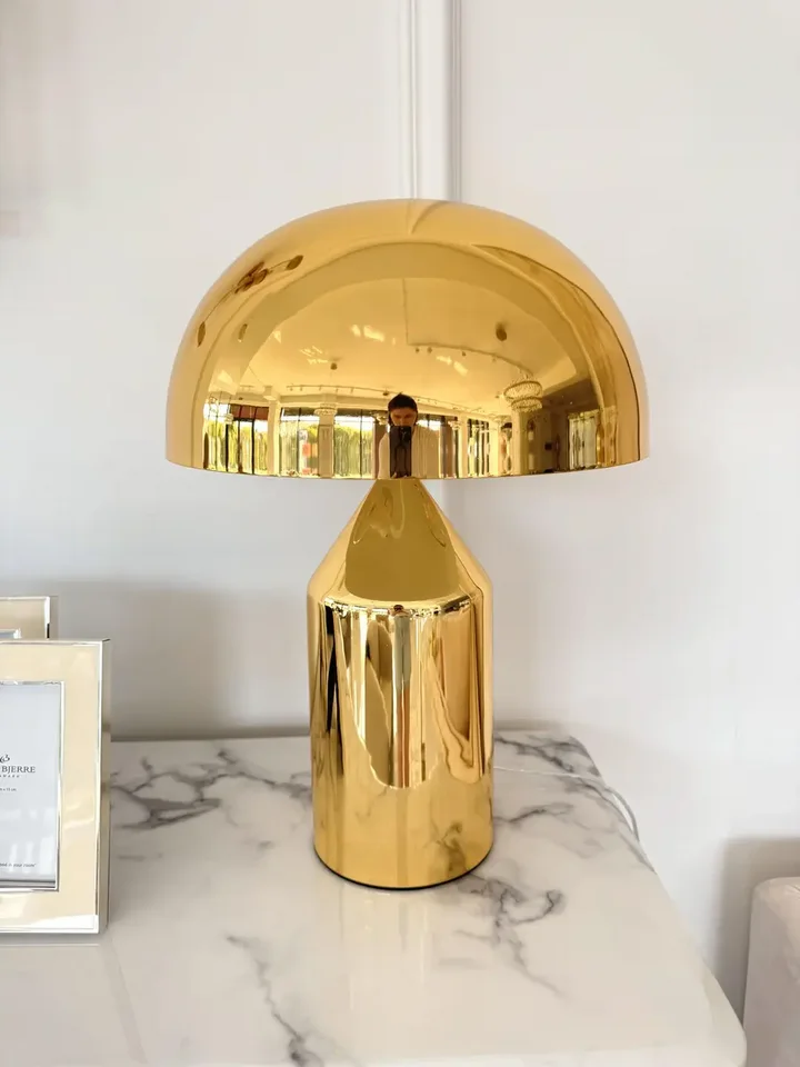 Nowoczesna lampa stołowa, stalowa, art deco, klasyczna, nowojorska, złota AURORA widoczna z boku w eleganckim wnętrzu. Ekspozycja w salonie od Primavera Home.