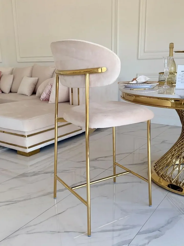 NOWOŚCI -- Hoker w stylu włoskim beżowy złoty nowoczesny desing JULIA przedstawiony w sposób siedzenia. Ekspozycja w salonie od Primavera Home.